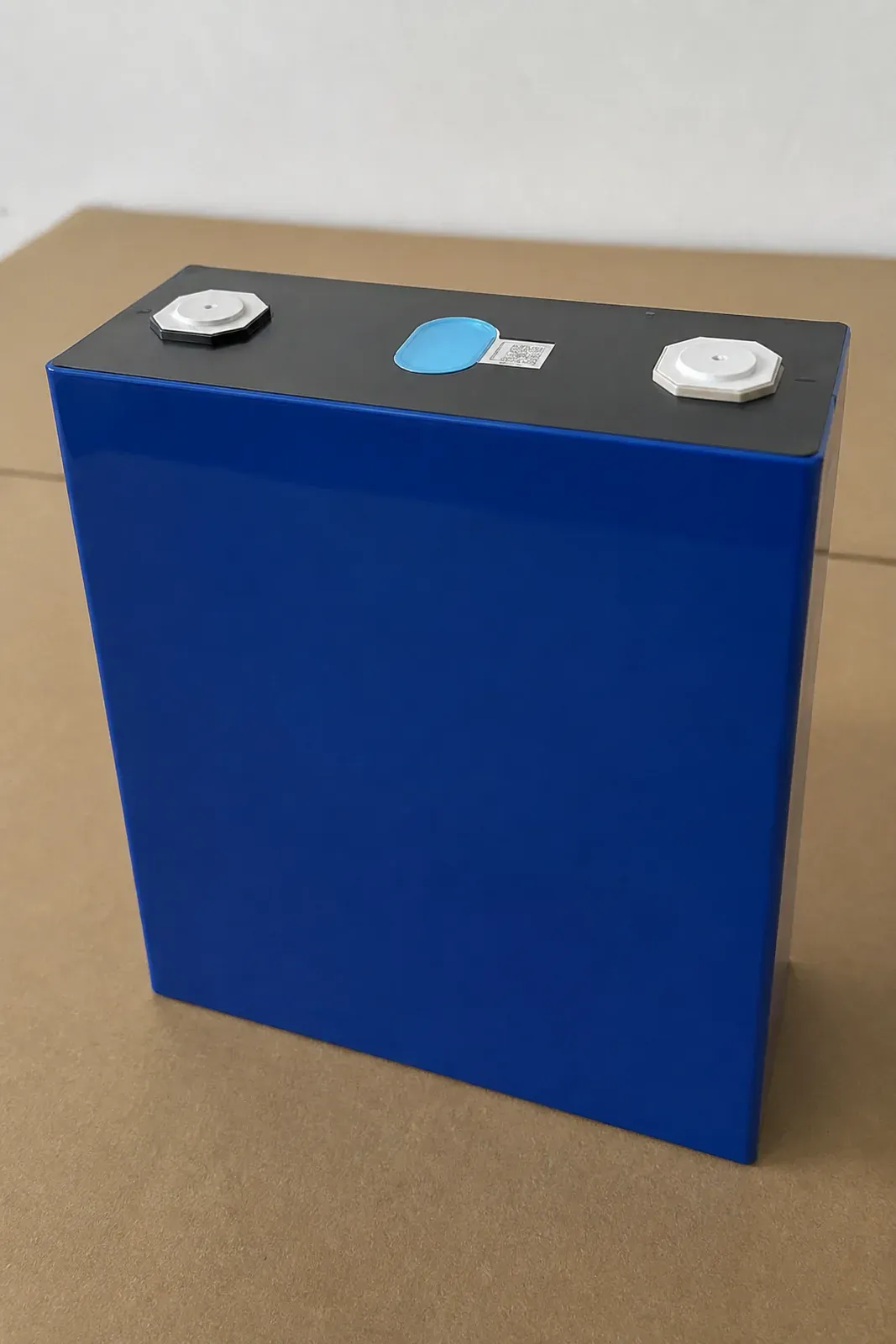 Top view of large prismatic lithium cell showing aluminum terminals, laser-welded explosion vent, and laser QR barcode