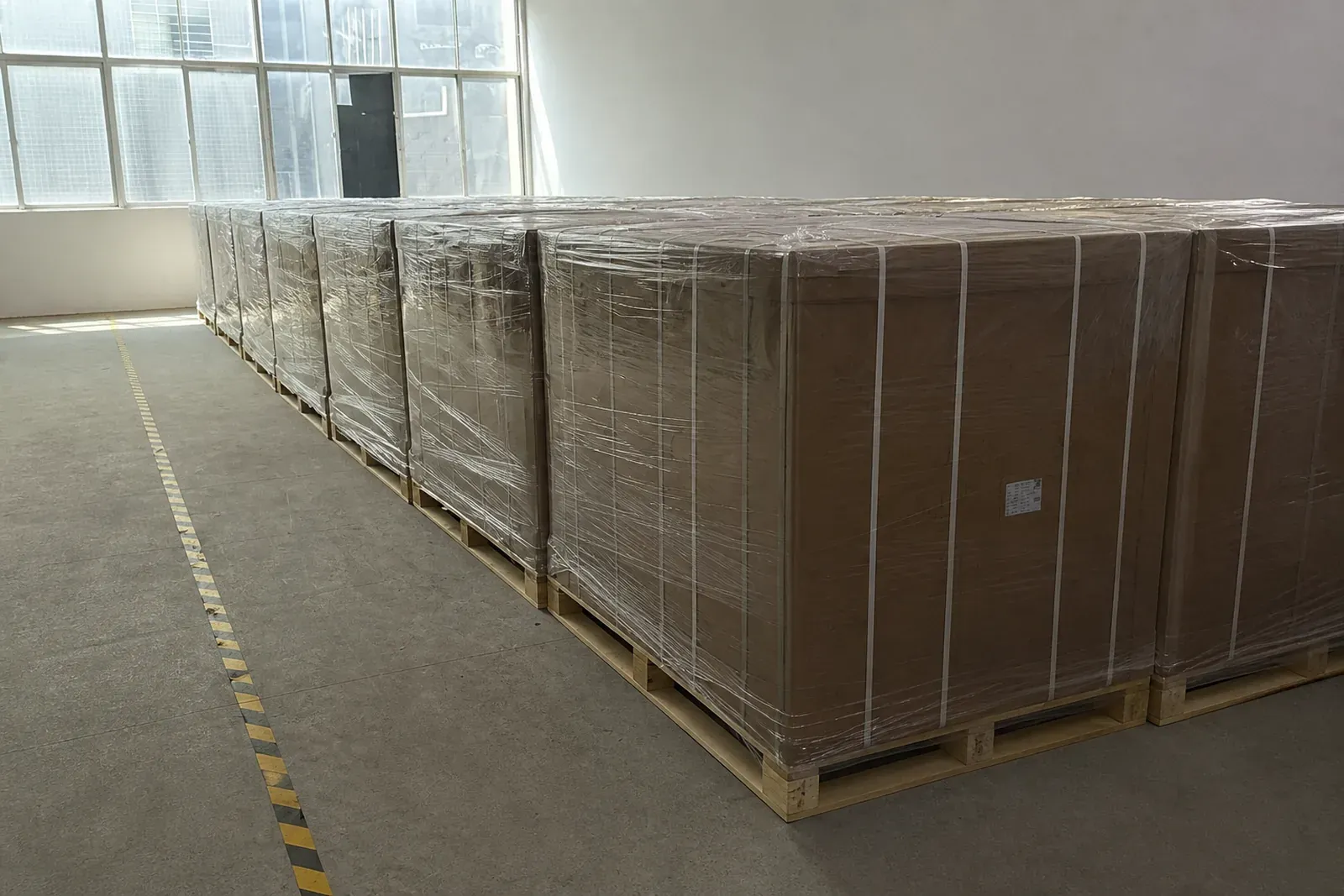 重型出口包装箱在托盘上完成高强度缠绕拉伸膜固定，防潮防尘待运