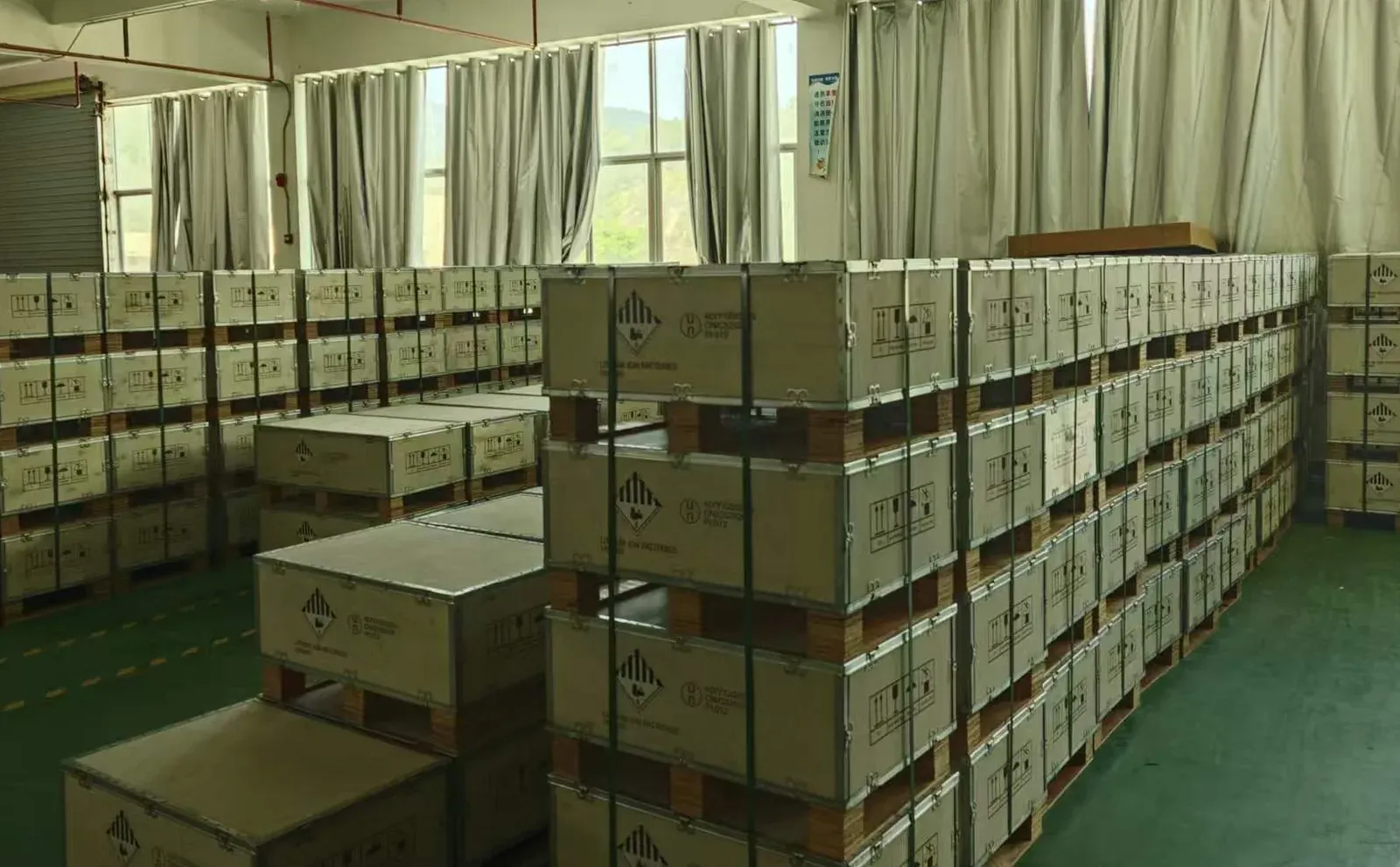 装配完毕的工业锂电池成品包整齐摆放在 UN 认证出口木箱旁边，准备装箱